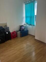 bedroom with wooden flooring and a window with turquoise curtains