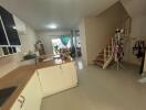 Spacious kitchen with integrated living area featuring modern design and staircase