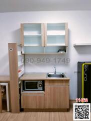 Compact modern kitchen setup with wooden cabinets and essential appliances