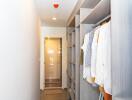 Modern bedroom walk-in closet with clothes and storage compartments