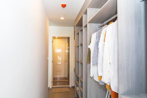 Modern bedroom walk-in closet with clothes and storage compartments