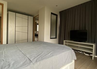 Spacious modern bedroom with large bed and mounted TV