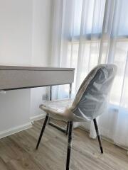 Modern bedroom with a desk and chair covered in protective plastic