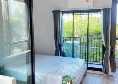 Modern bedroom with glass sliding doors and view of greenery