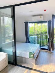 Modern bedroom with glass sliding doors and view of greenery