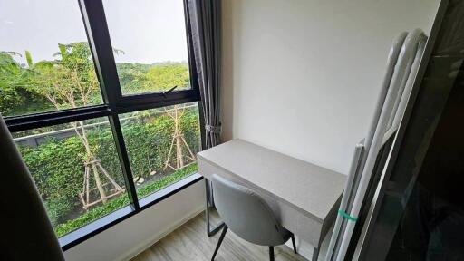 Bright bedroom with large window overlooking greenery