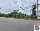 Roadside view of a property with surrounding greenery and infrastructure