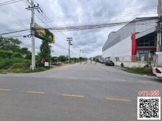 Exterior view of a property with street view, showing warehouses and a cloudy sky