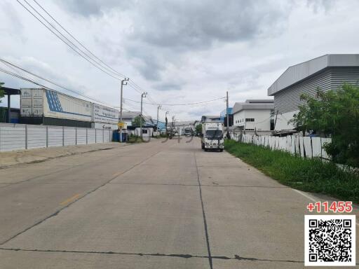 Industrial area with factories and clear roads under cloudy sky