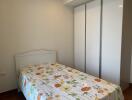 Bright and well-furnished bedroom with floral bedsheet and large closet