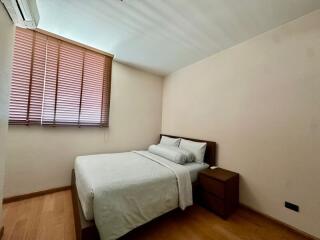 Simple and cozy bedroom with a double bed and wooden furniture