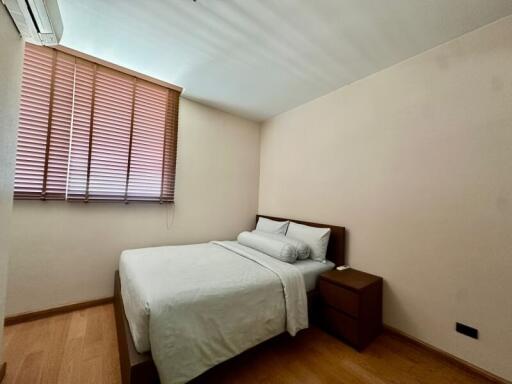 Simple and cozy bedroom with a double bed and wooden furniture