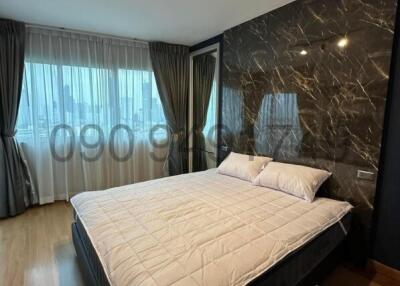 Spacious bedroom with luxurious marble wall and large windows