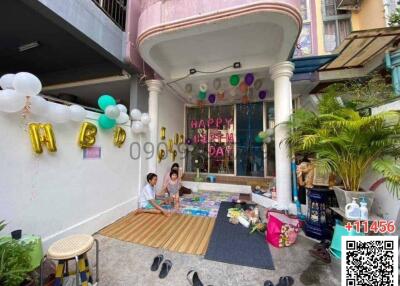 Family celebrating a birthday party outside a residential building