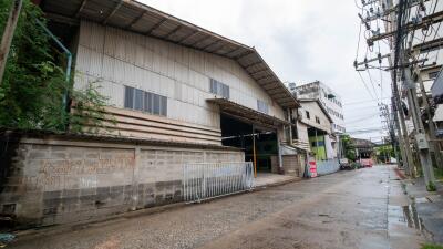 Exterior view of a large industrial building with street in front