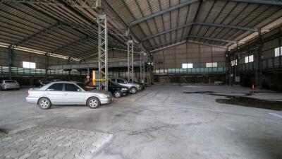 Spacious industrial warehouse interior with parked cars