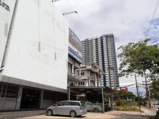 Urban high-rise buildings under construction next to a street with parked cars