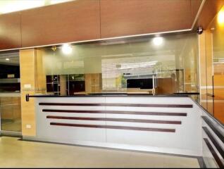 Modern reception area with glass partition and wooden accents