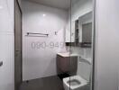 Modern white bathroom with glass shower enclosure and efficient layout