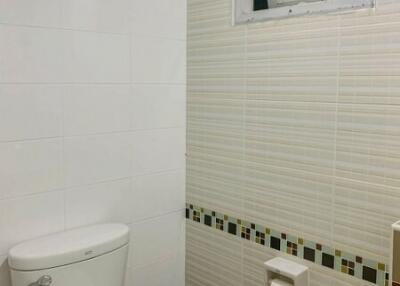 Compact bathroom with white and striped tiles
