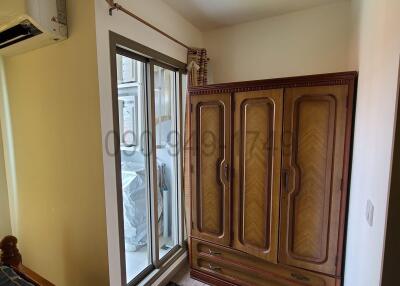 Compact bedroom with wooden wardrobe and access to balcony