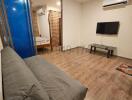 Modern bedroom with wooden flooring, comfortable bed, and wall-mounted TV