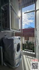 Bright balcony area with laundry appliances and scenic view