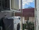 Bright balcony area with laundry appliances and scenic view