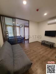 Spacious living room with view into bedroom, modern furniture and ample lighting