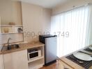 Compact modern kitchen with white cabinetry and essential appliances