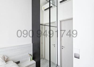 Modern minimalist bedroom with sleek black framed glass wardrobe