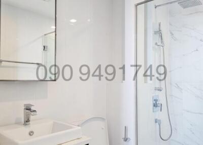 Modern bathroom with white fixtures and marble detailing