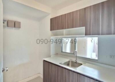 Compact and modern kitchen interior with wooden cabinets and stainless steel sink