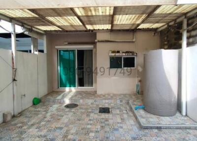 Spacious covered patio area with patterned tile flooring and essential utilities