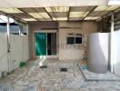 Spacious covered patio area with patterned tile flooring and essential utilities