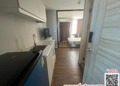 Modern apartment interior view showing a kitchen leading to a bedroom