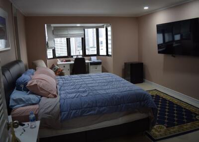 Modern bedroom with a large bed, wall-mounted TV, and window