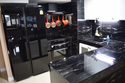 Modern kitchen with black marble finish and well-equipped appliances