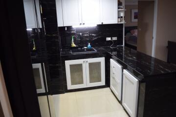 Modern kitchen with black marble countertops and white cabinetry