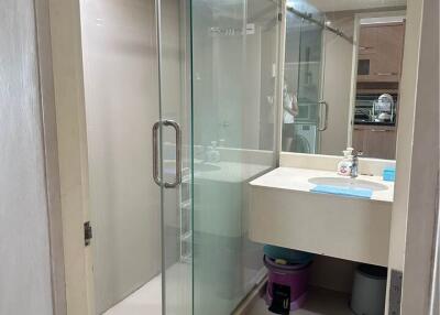 Modern bathroom with glass shower enclosure and well-lit vanity area