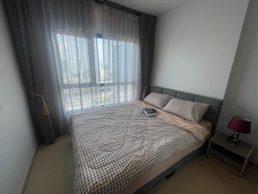 Modern bedroom with city view through large windows