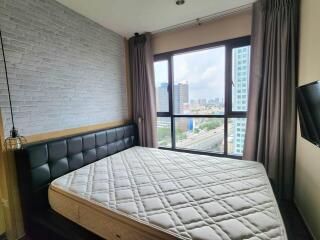 Modern bedroom with large window and urban view