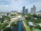 Aerial view of urban landscape showcasing residential buildings, a school, and surrounding greenery