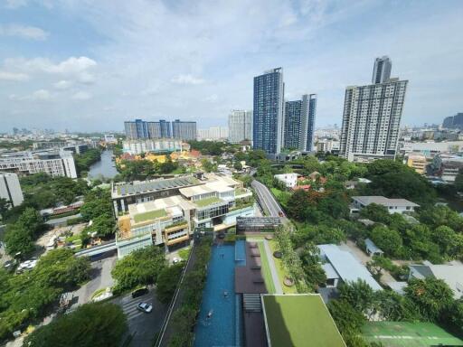 Aerial view of urban landscape showcasing residential buildings, a school, and surrounding greenery