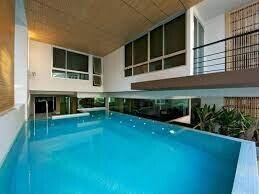 Modern indoor pool with large windows and balcony in a luxury home