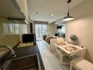 Modern studio apartment interior with kitchen, dining area, and bedroom in the background