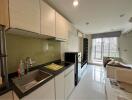 Modern kitchen with adjacent living area in a bright apartment