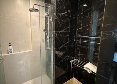 Modern bathroom with marble walls and glass shower enclosure