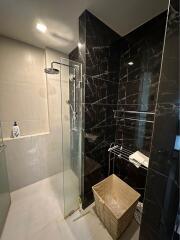 Modern bathroom with marble walls and glass shower enclosure