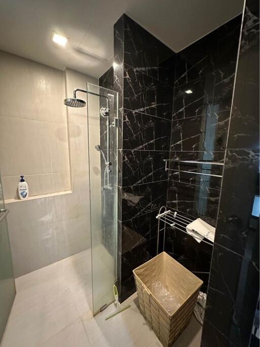 Modern bathroom with marble walls and glass shower enclosure